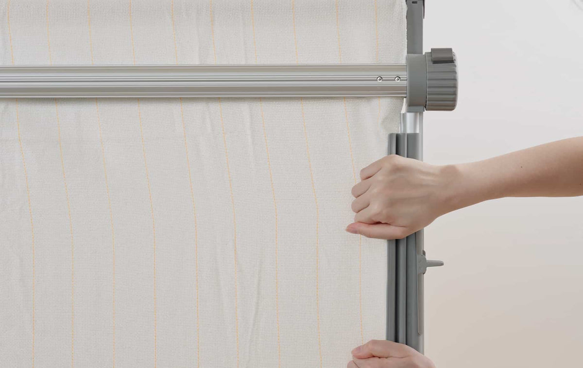 Clawlab tufting frame stretching taut white fabric with orange stripes.